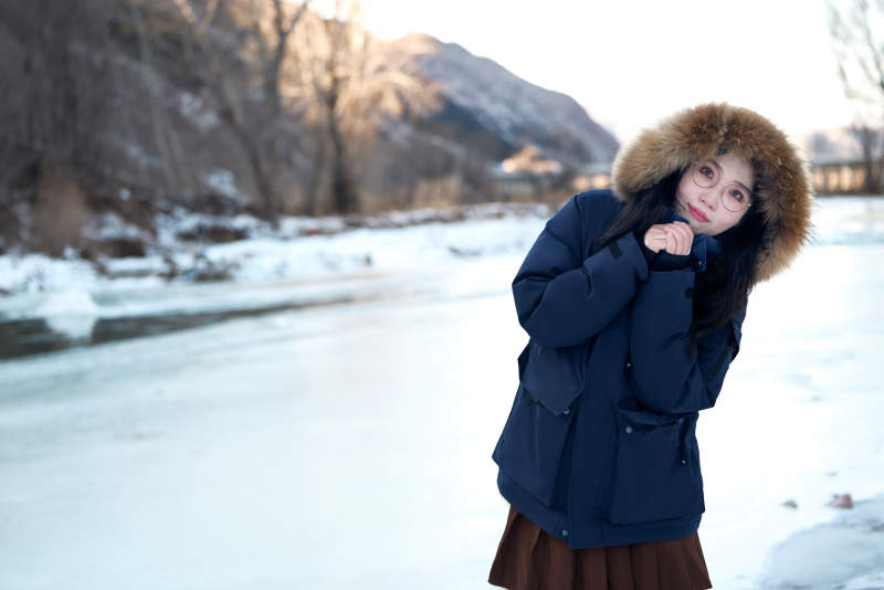 在野外雪地欣赏雪景游玩拍照的亚洲女性图片