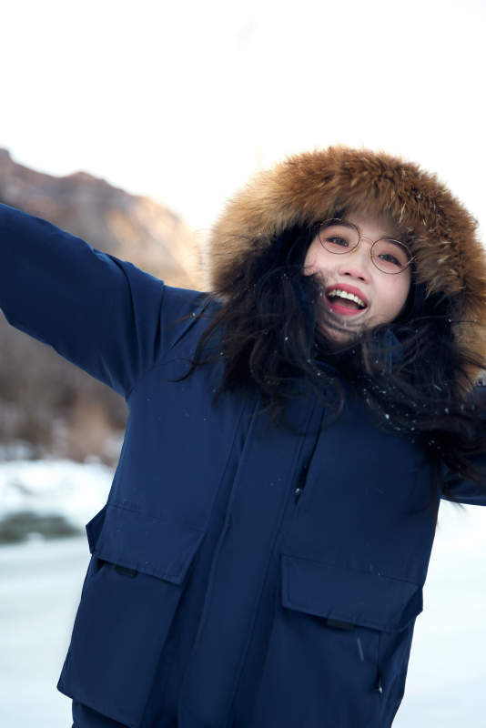 在野外雪地欣赏雪景游玩拍照的亚洲女性图片