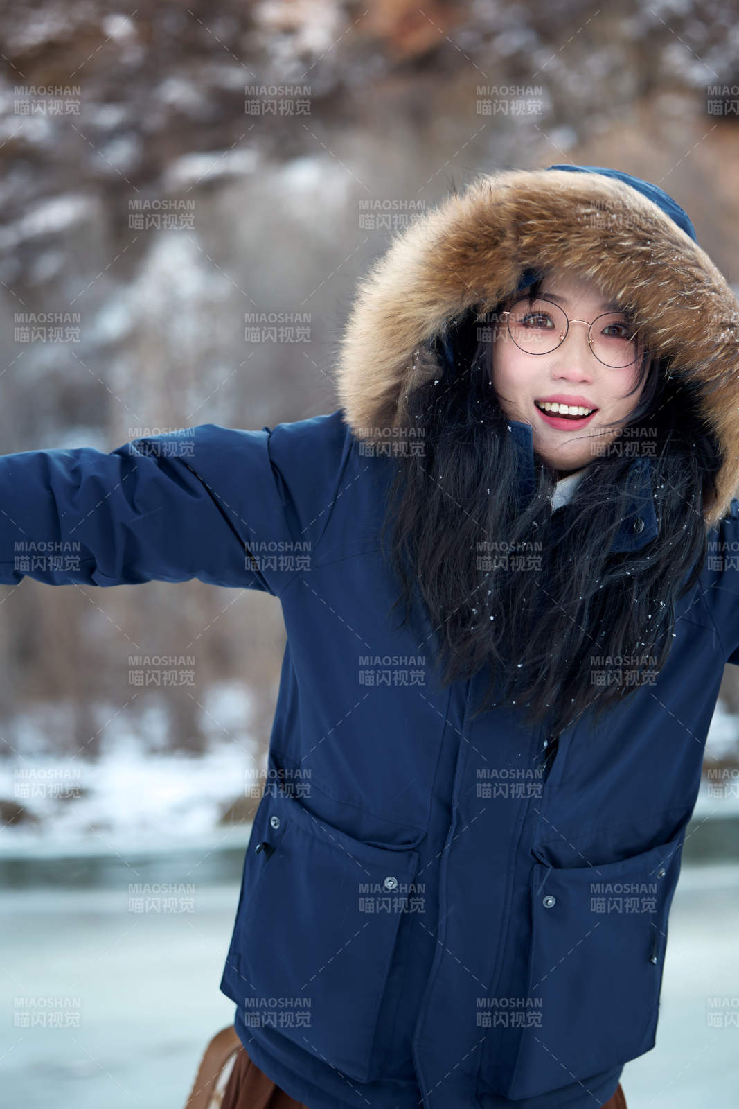 在野外雪地欣赏雪景游玩拍照的亚洲女性图片