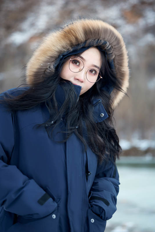 在野外雪地欣赏雪景游玩拍照的亚洲女性图片