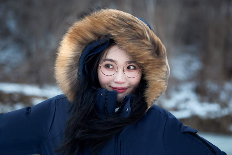 在野外雪地欣赏雪景游玩拍照的亚洲女性图片