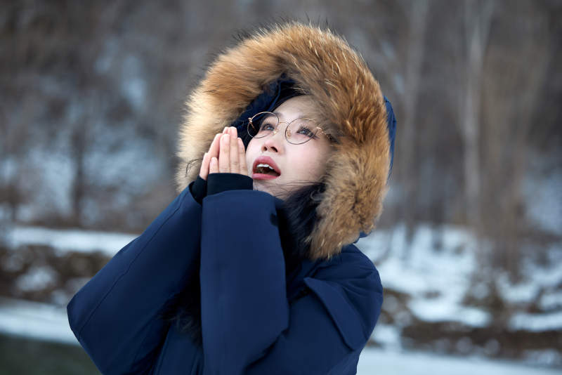 在野外雪地欣赏雪景游玩拍照的亚洲女性图片