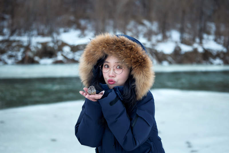 在野外雪地欣赏雪景游玩拍照的亚洲女性图片