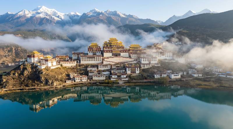 雪山映湖畔古寺图片