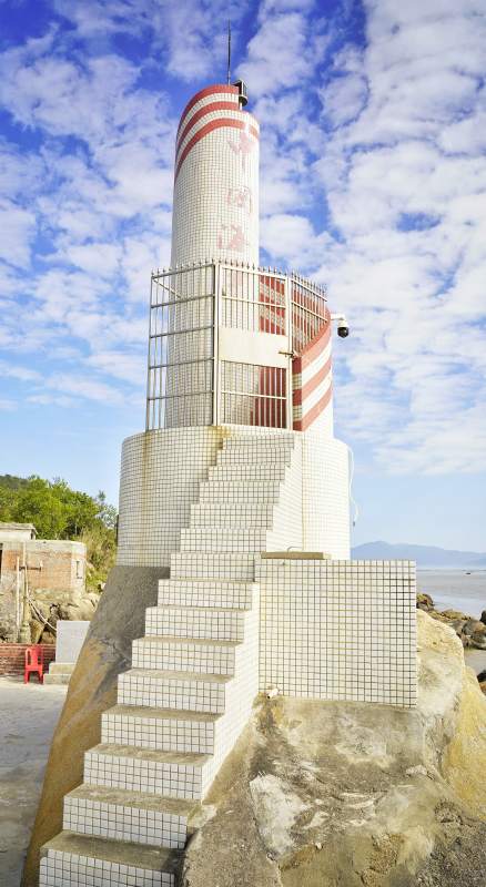 红白灯塔矗立海边图片