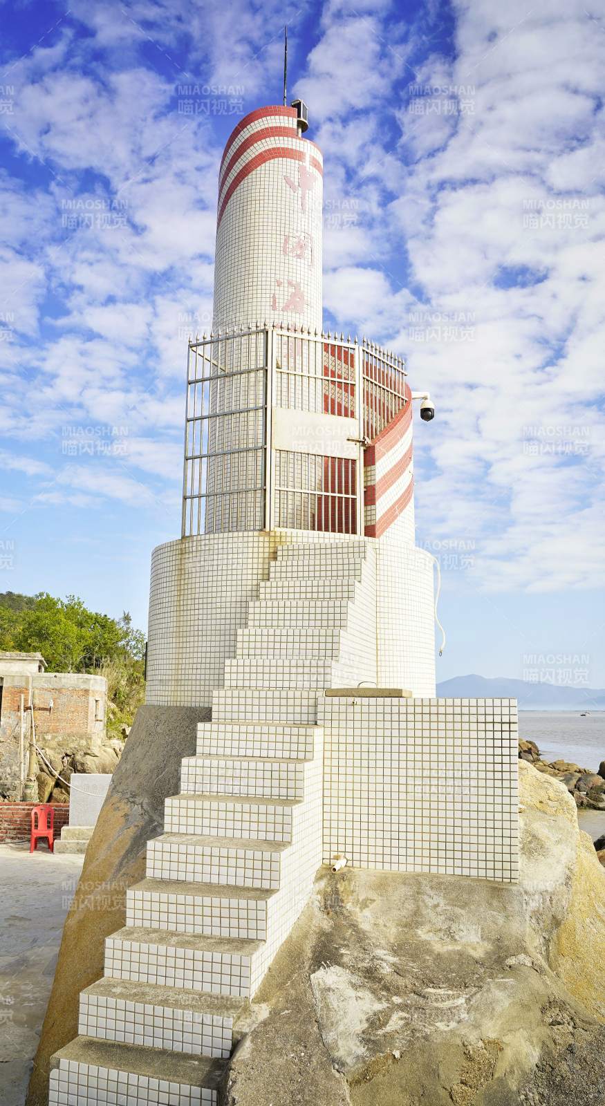 红白灯塔矗立海边图片