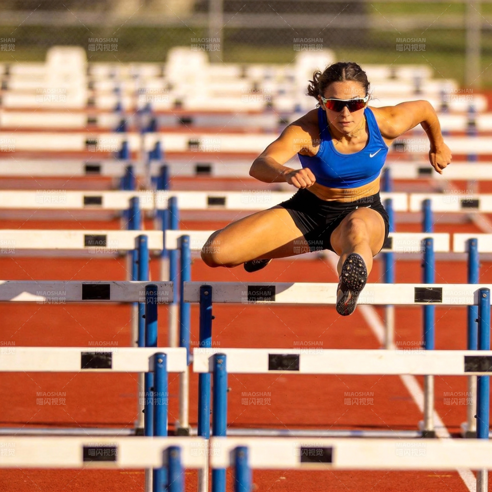 跨栏女子跃过障碍图片