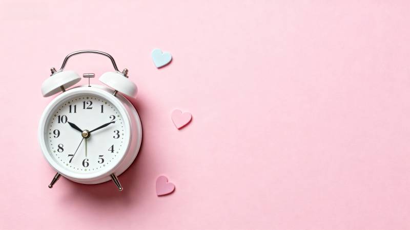 粉色背景上的闹钟与爱心图片