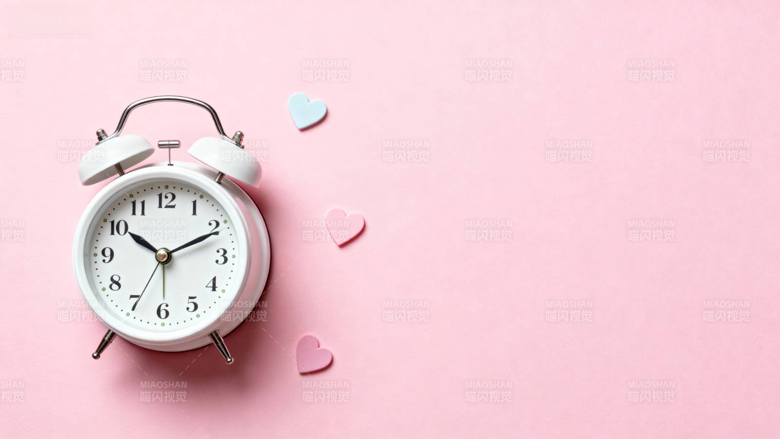 粉色背景上的闹钟与爱心图片