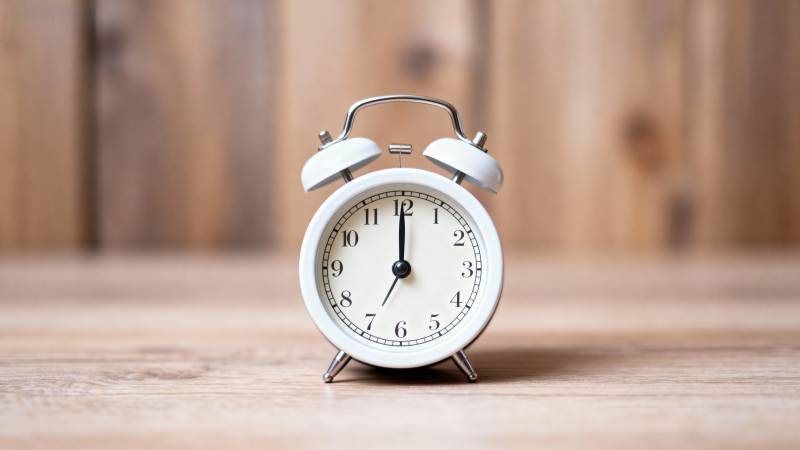 复古闹钟静置木桌图片