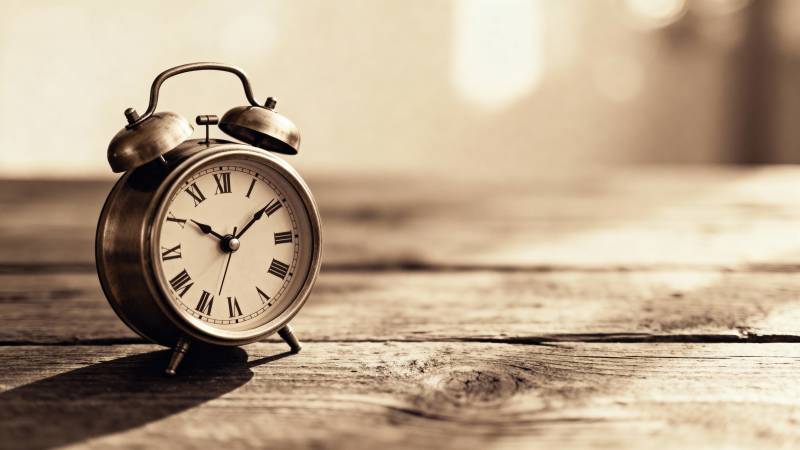 复古闹钟静置木桌图片