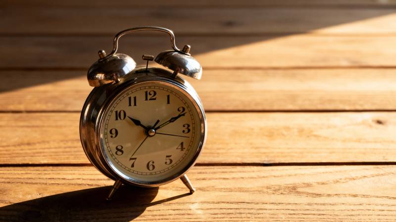 复古闹钟静置木桌图片