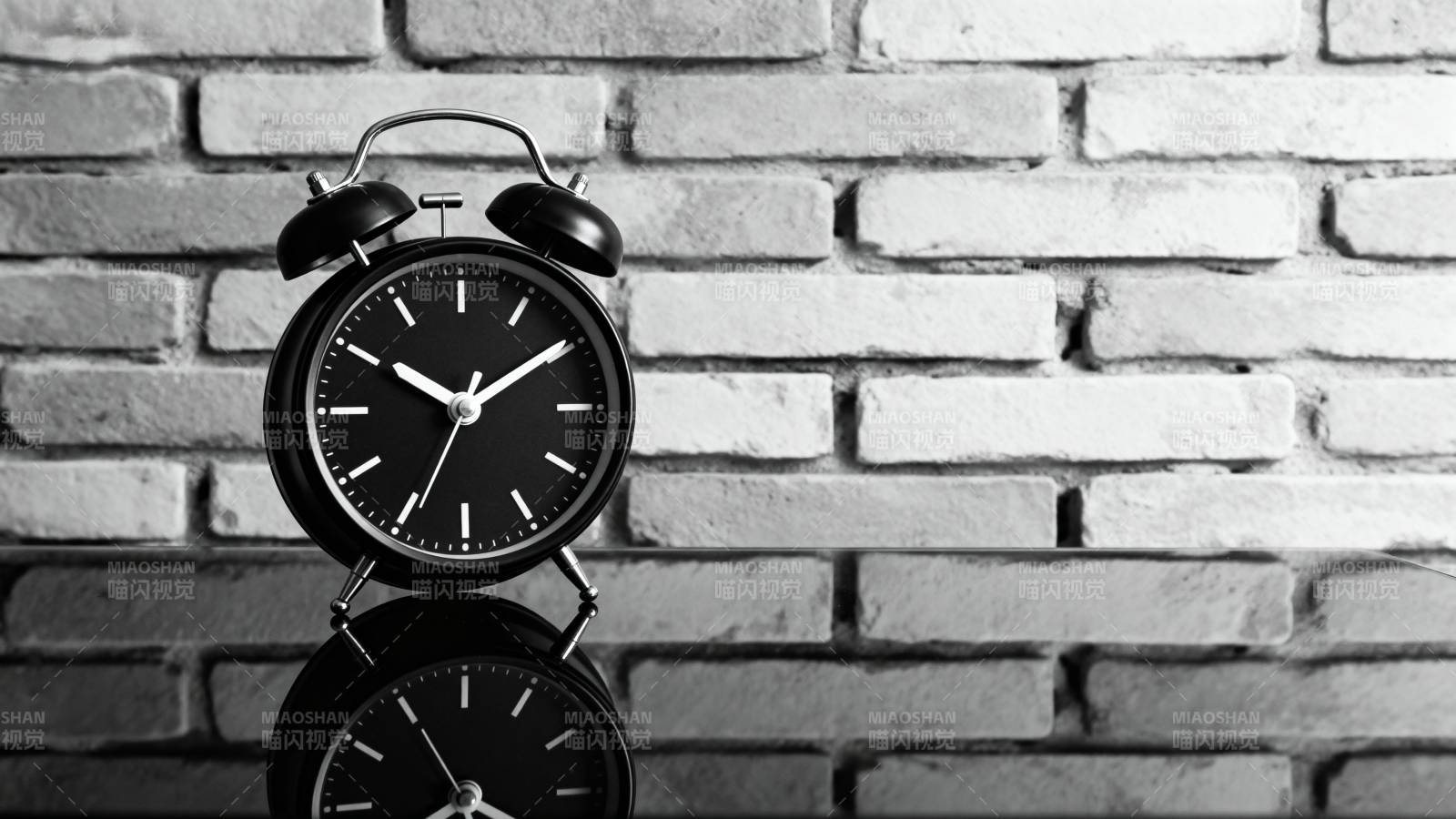 复古闹钟静置砖墙前图片