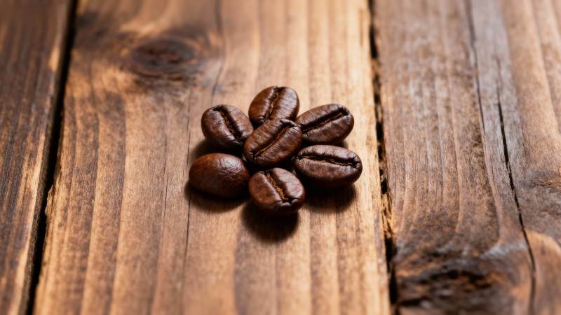 咖啡豆静置于木桌图片