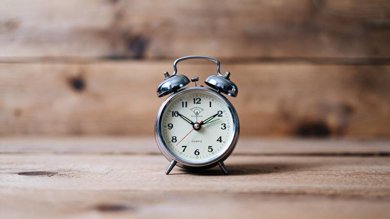 复古闹钟静置木桌图片