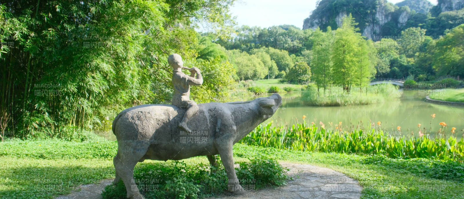 童骑牛雕像湖畔图片
