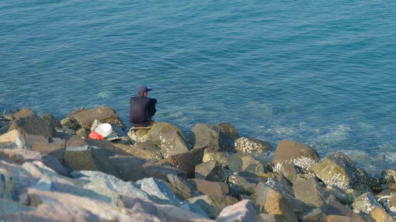 海边静坐垂钓人图片