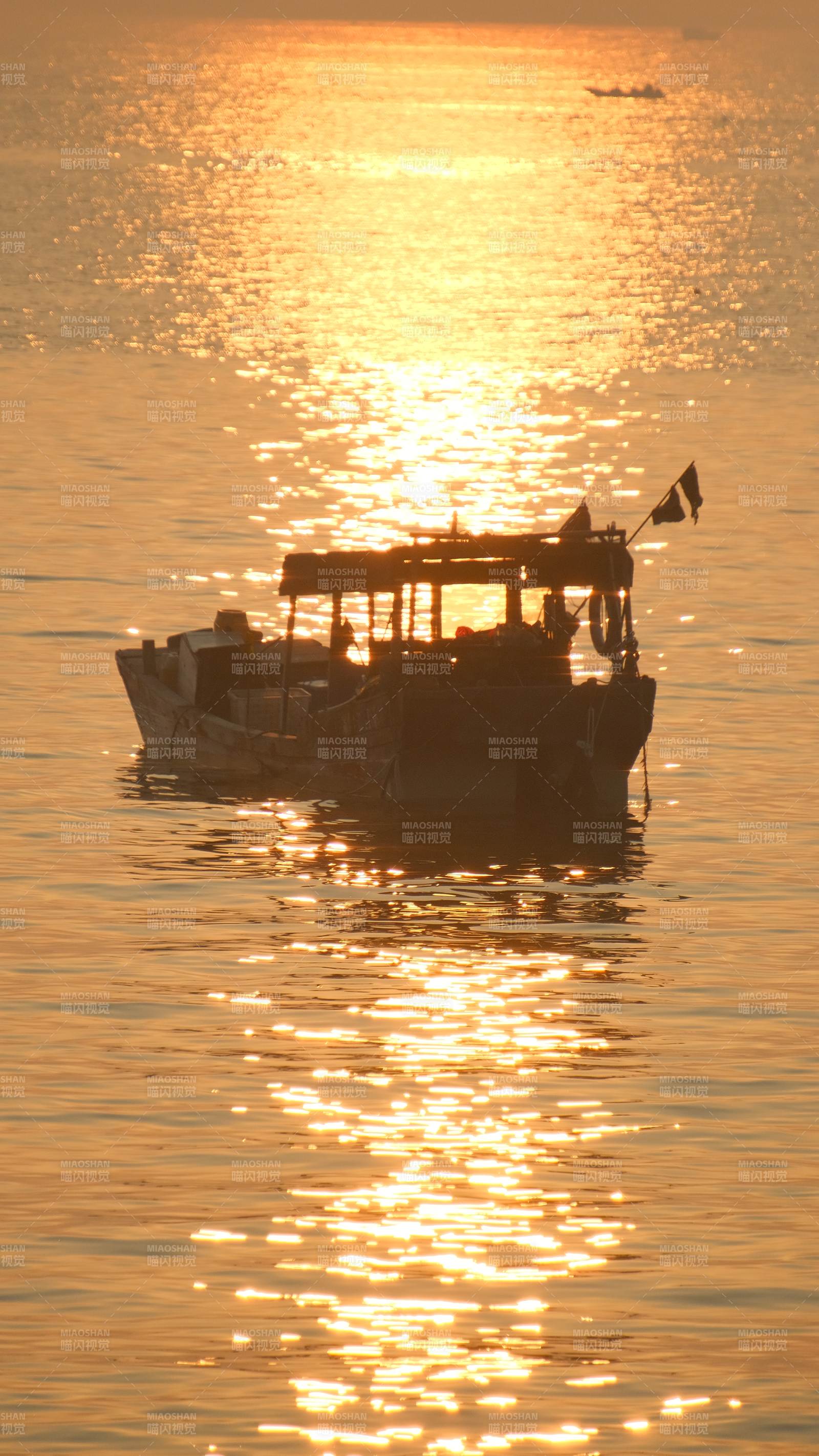 夕阳下的渔船剪影图片