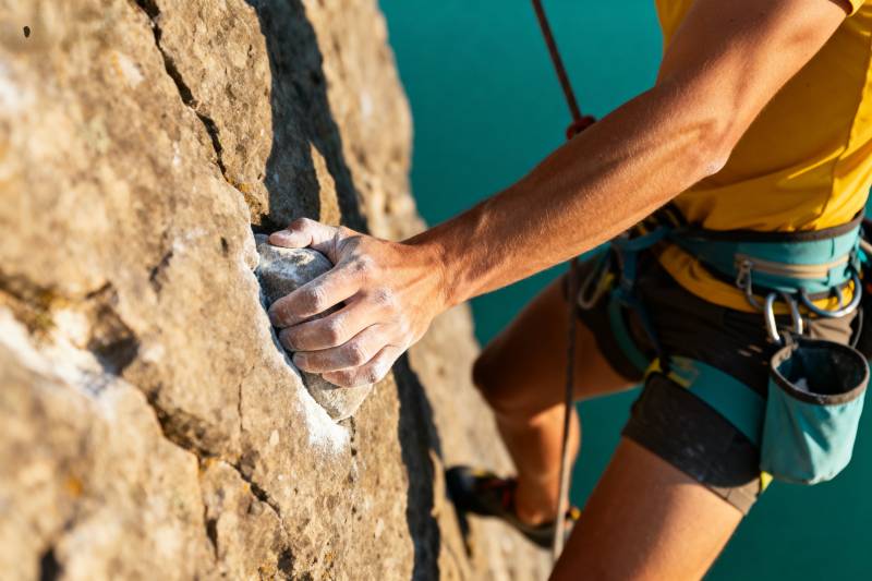 攀岩者紧握岩壁图片