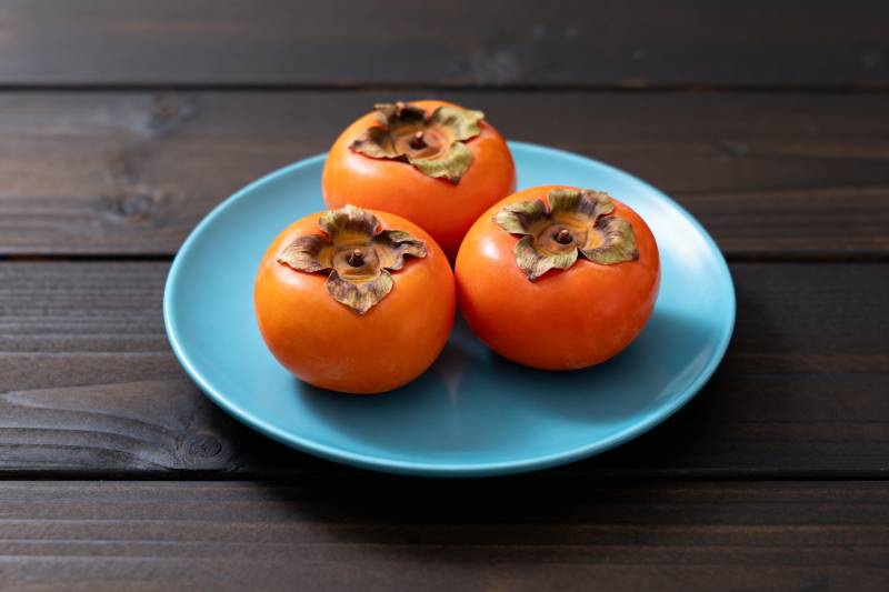 三颗柿子盘中静置图片