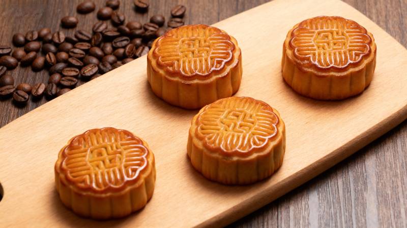 月饼与咖啡豆静置木板上图片