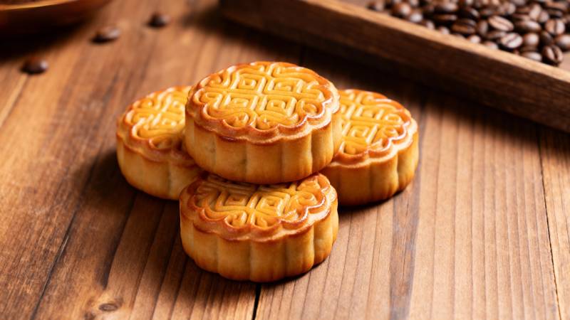 金黄月饼叠放木桌图片