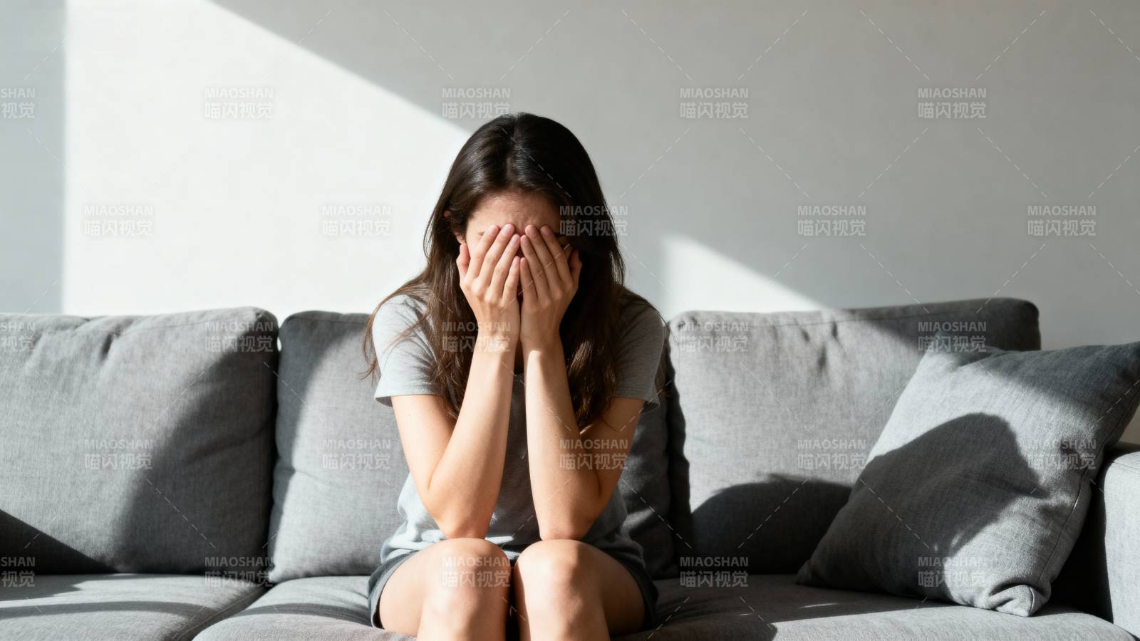 女子掩面坐沙发图片