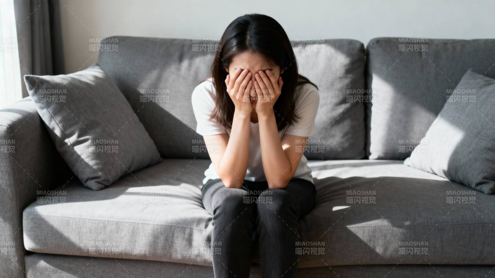 女子掩面坐在沙发上图片