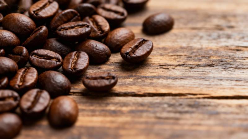 咖啡豆散落木桌图片