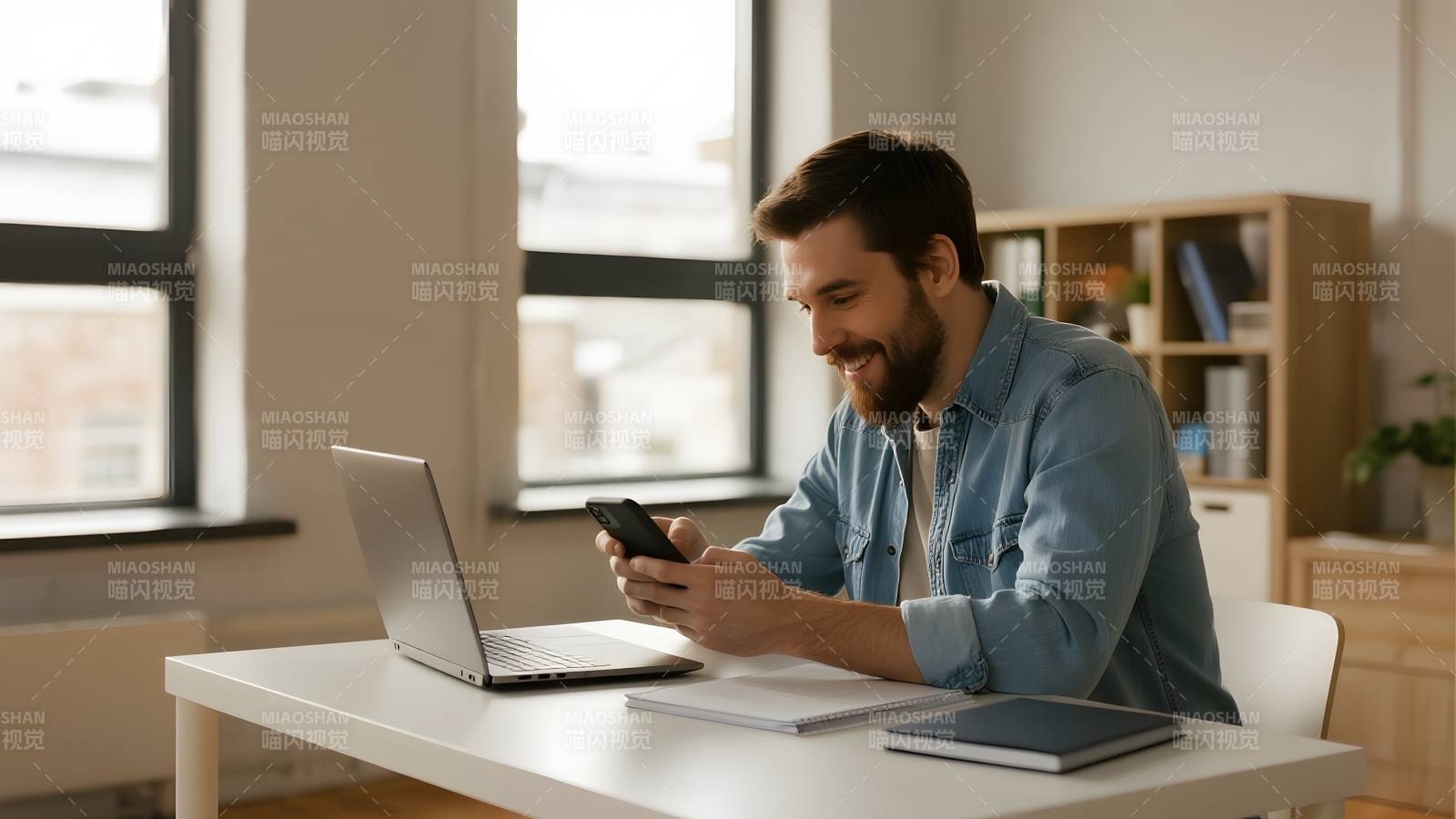 男子办公桌前使用手机图片