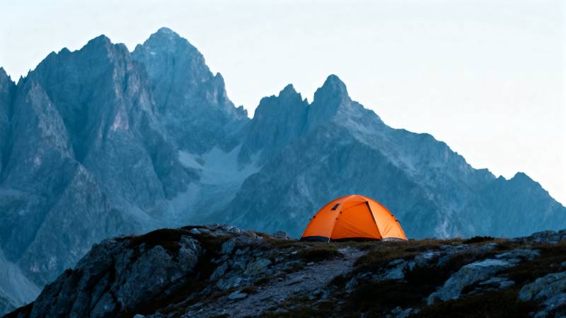 雪山之巅的橙色帐篷图片