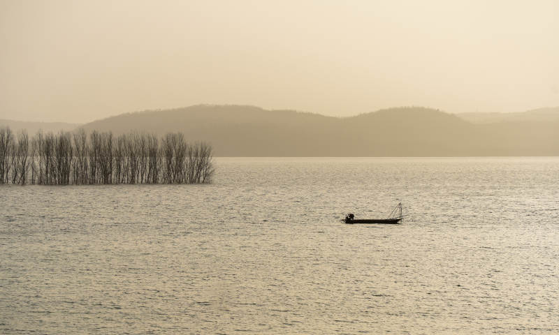 湖上孤舟远山影图片
