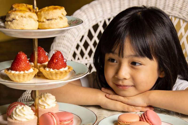 小女孩与三层甜点架的温馨瞬间图片