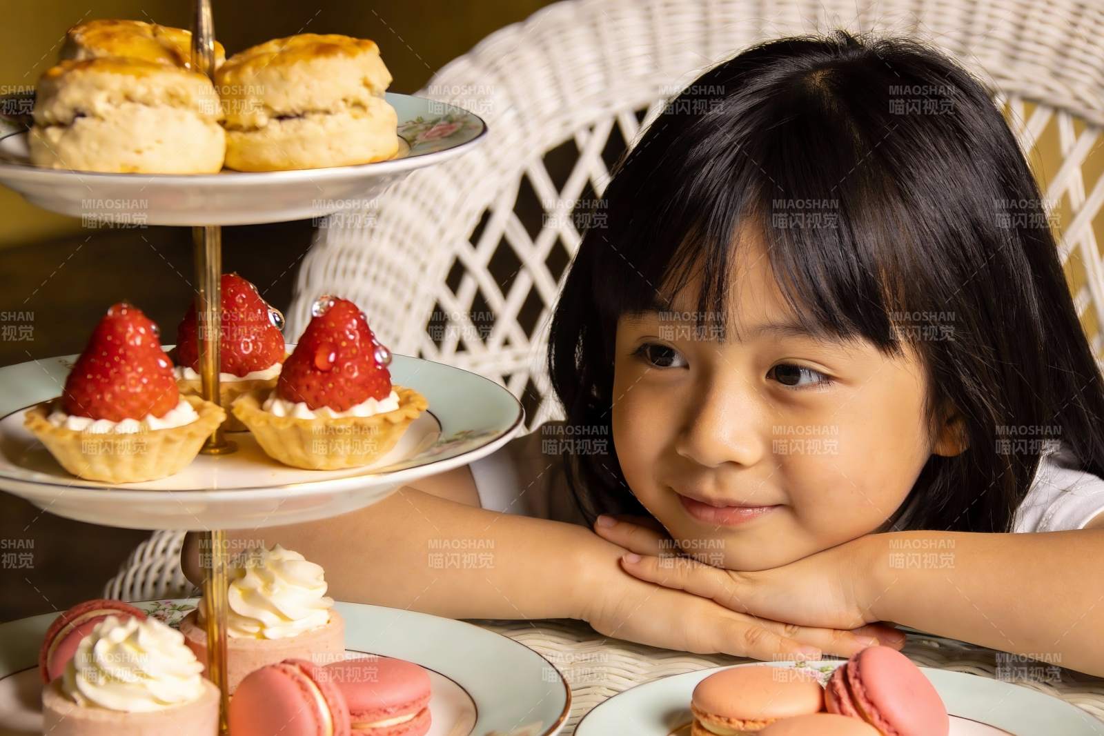 小女孩与三层甜点架的温馨瞬间图片