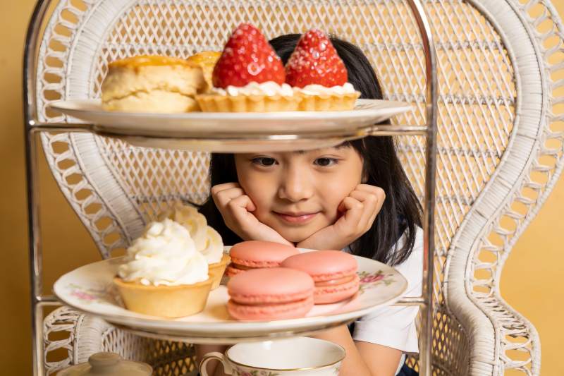 小女孩与三层甜点架的温馨瞬间图片