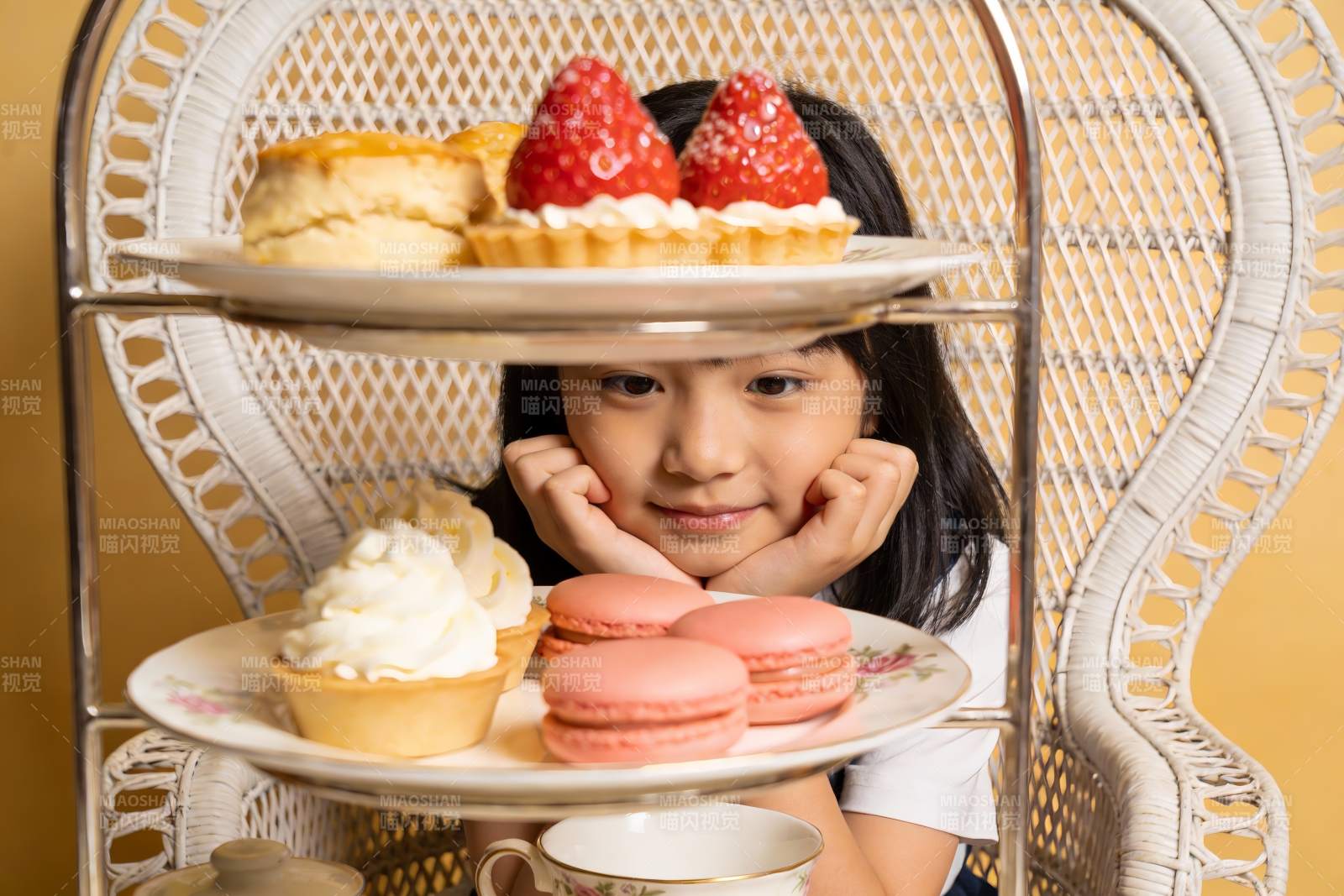 小女孩与三层甜点架的温馨瞬间图片