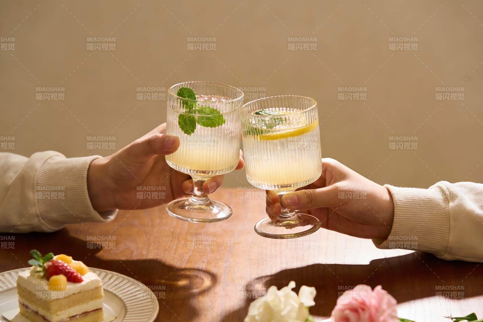 两人举杯碰杯享受饮品与甜点图片