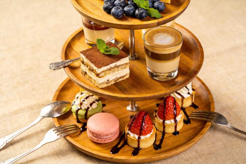 三层木质甜品架摆满精致糕点图片