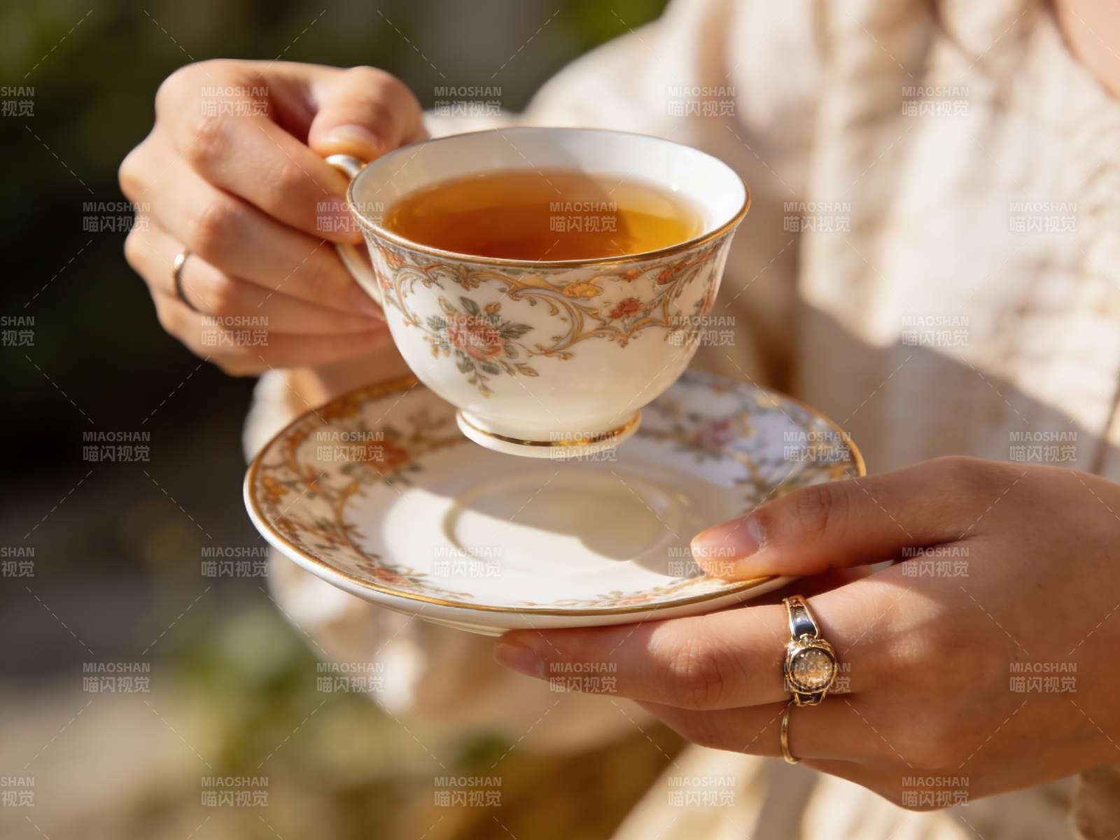 优雅手持花瓷茶杯品茗图片
