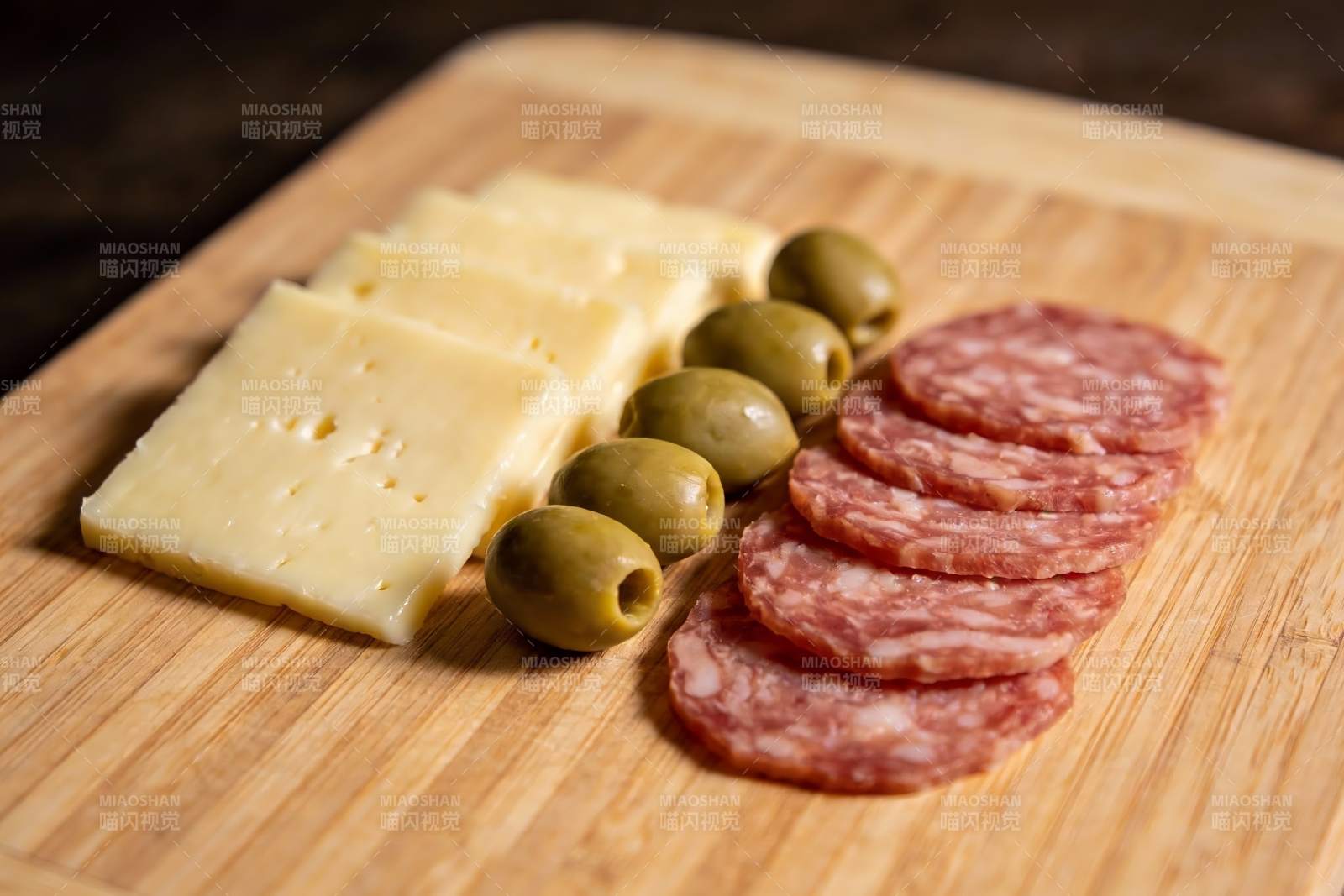 木质砧板上的奶酪香肠橄榄图片