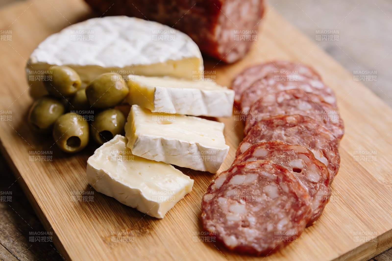 木质盘上的奶酪香肠橄榄图片