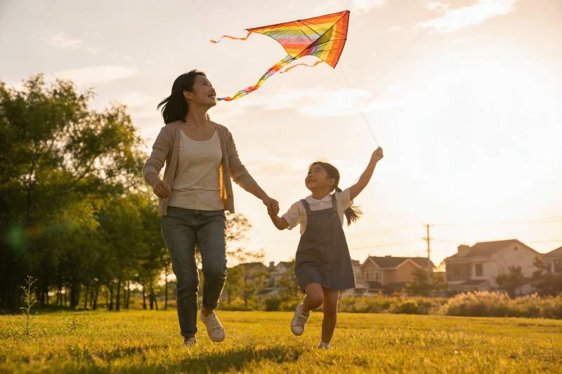母女草地上放风筝欢乐奔跑图片