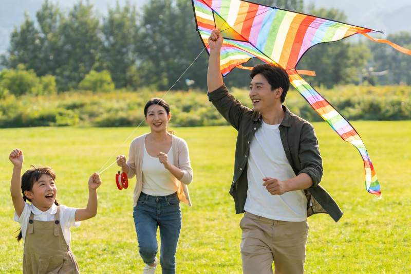 一家三口户外放风筝欢乐场景图片