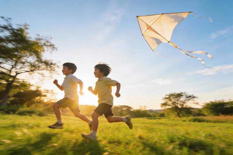 两个男孩草地上奔跑放风筝图片