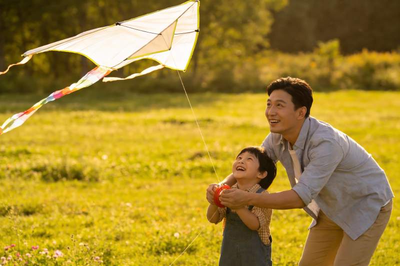 父子草地上放风筝欢乐时光图片