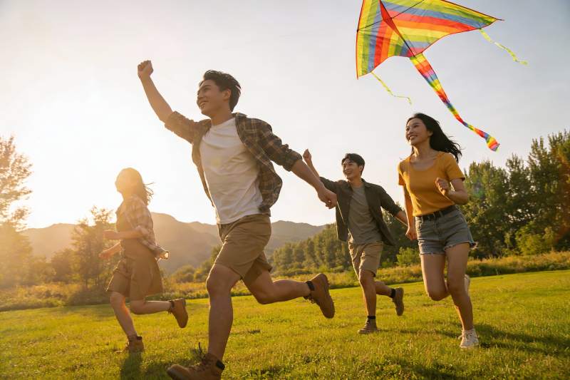 四人户外奔跑放风筝图片