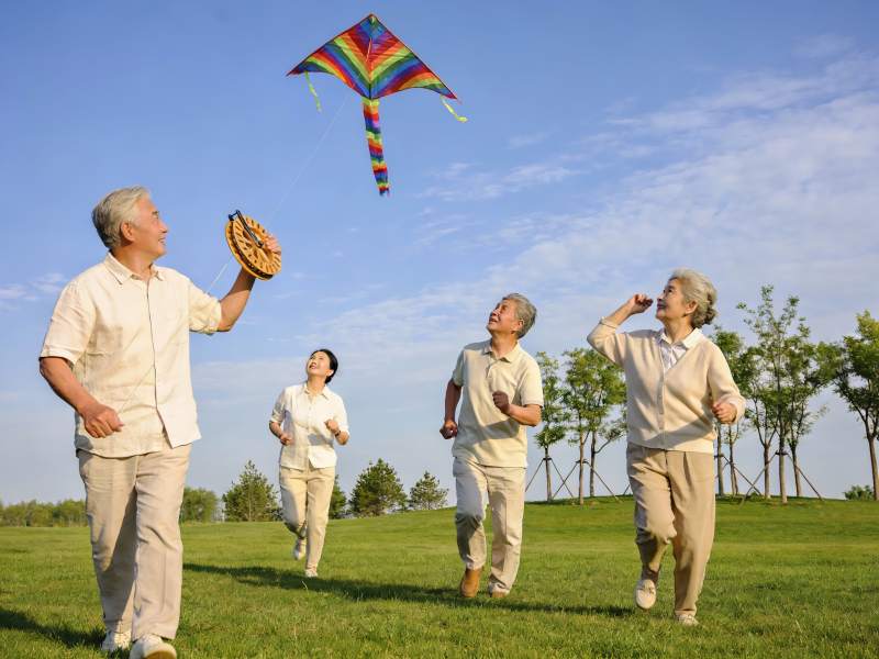 老人户外放风筝跑步图片