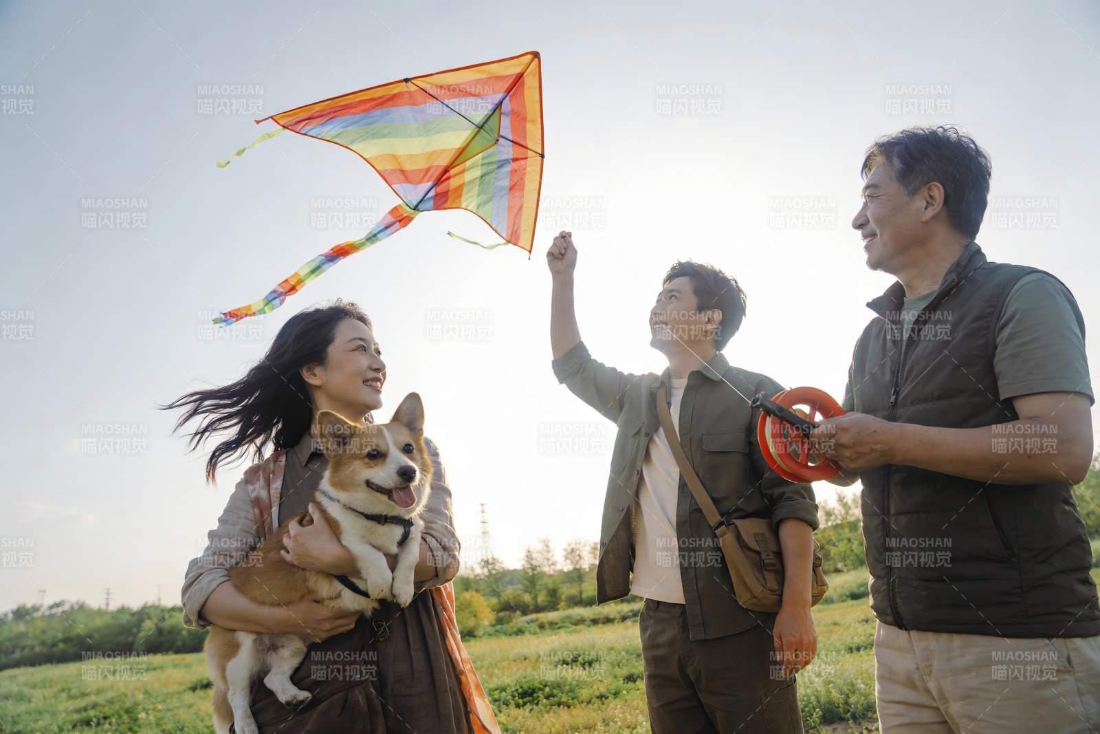 家人户外放风筝与宠物同乐图片