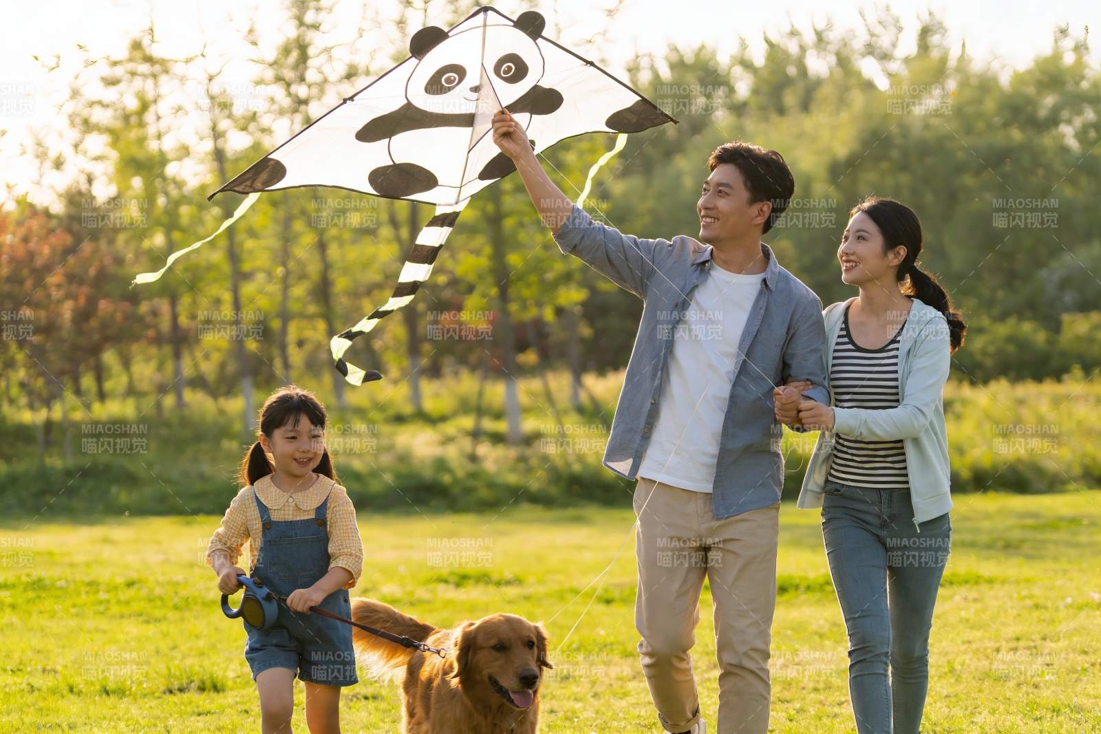 一家三口公园放风筝遛狗图片