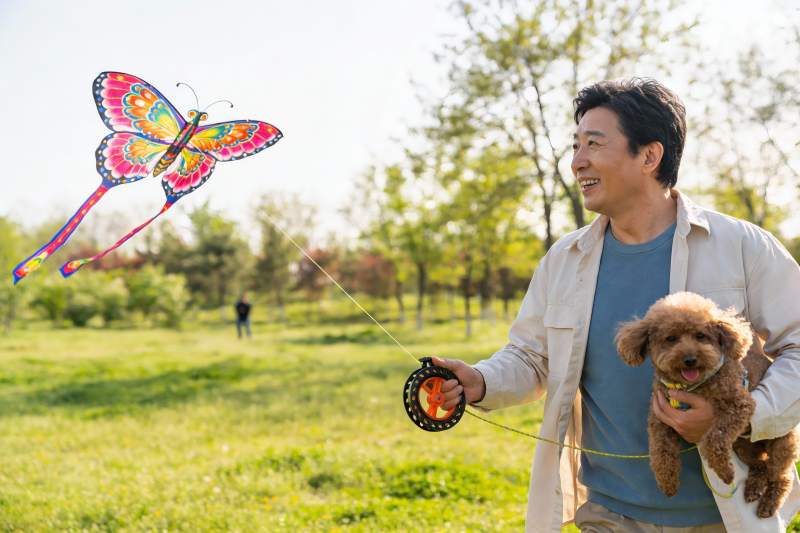 男子公园放风筝抱狗图片